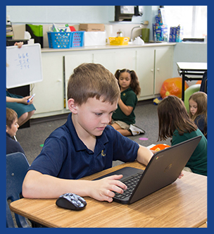2nd grader working on a laptop in the classroom