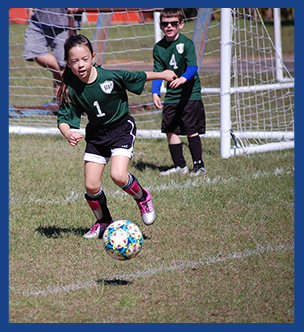 Students outside playing in a soccer game