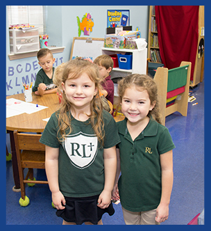 Two happy school girls posing for a picture in the classroom